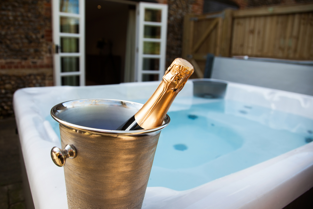 Bottle,Of,Champagne,Cooling,By,Hot,Tub